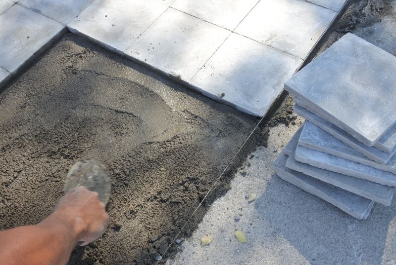 Person leveling exterior floor for a tiling installation