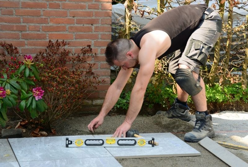 Exterior tilers leveling a tile floor