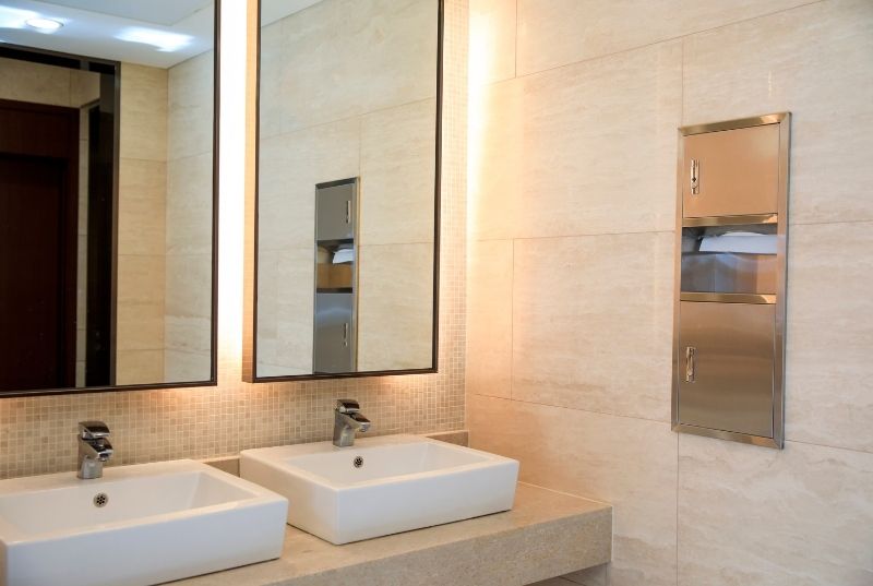 Commercial bathroom tiling with a double sink vanity and matching double mirror