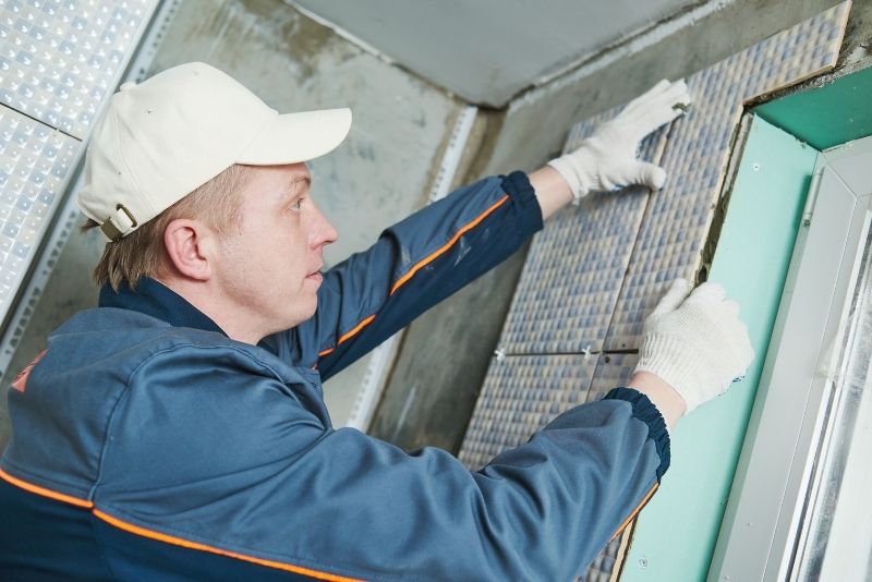 Tiler installing a tile on a bathroom renovation project