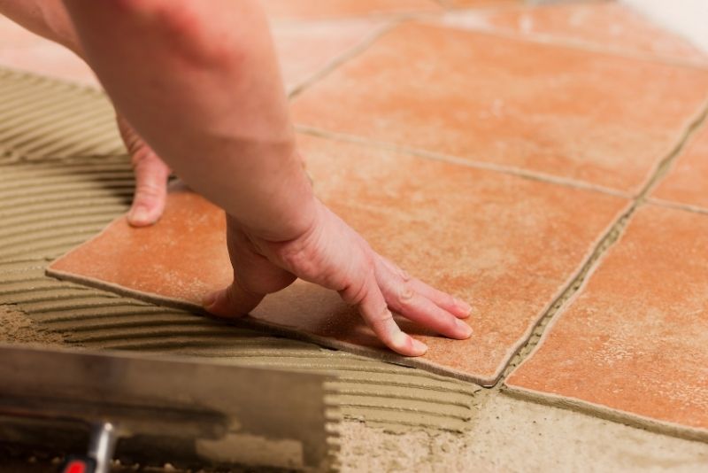 Staff from Tilers Port Kembla laying floor ceramic tiles